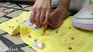 Goddess Kiffa crushes candies with her red-polished feet.