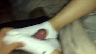Female colleague in white socks gives footjob ending with cumshot.