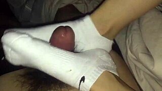 Female colleague in white socks gives footjob ending with cumshot.
