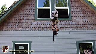 Why is this ballgagged slave dangling in tight bondage submission?