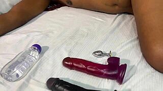 African beauty enjoys solo pleasure with a big black dildo and butt plug in her anus for an intense orgasm.