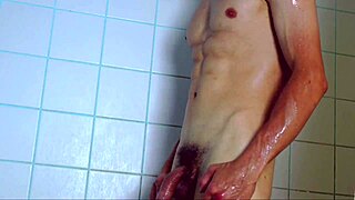 A young and attractive man with a great body washes himself and pleases himself in the shower.