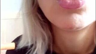 A sexy babe in a miniskirt smokes in a private setting.