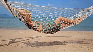 sexy babe in long dress flashes no panties on public beach close-up.