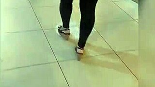 Mature woman with a big ass walks the street in tight leggings