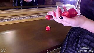 sqeezing juicy strawberry by cute bare feet closeup