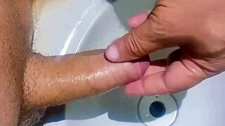 גבר מוסתר לחלוטין בכיור האמבטיה ומסיר זרע